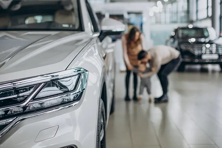 Сім’я оглядає SUV у автосалоні компанії ELVION, сучасний дизайн шоуруму.